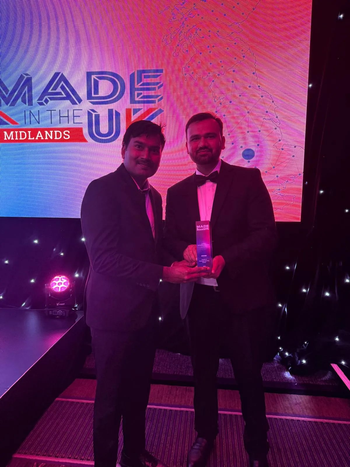 Sajanraj and a colleague accepting the Made In the Midlands AI Tech Innovation of the Year award on stage